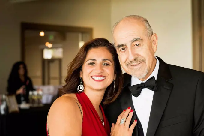 Hispanic father and daughter smiling at party