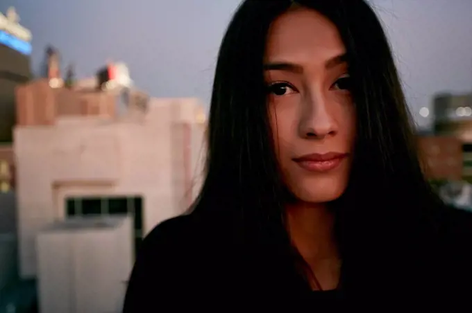 Serious mixed race woman on urban rooftop