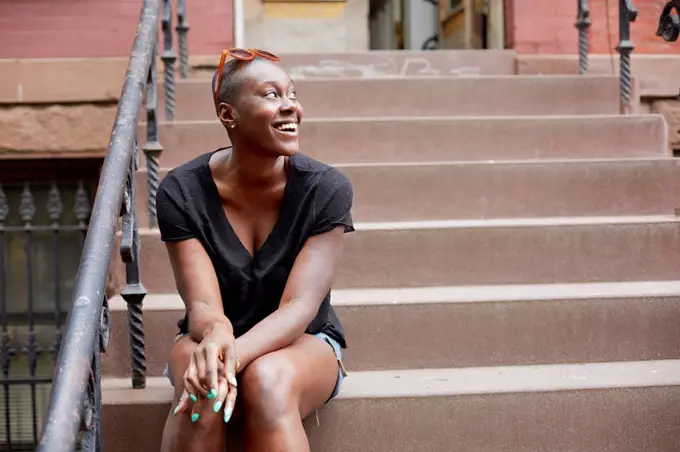 Black woman sitting on urban front stoop