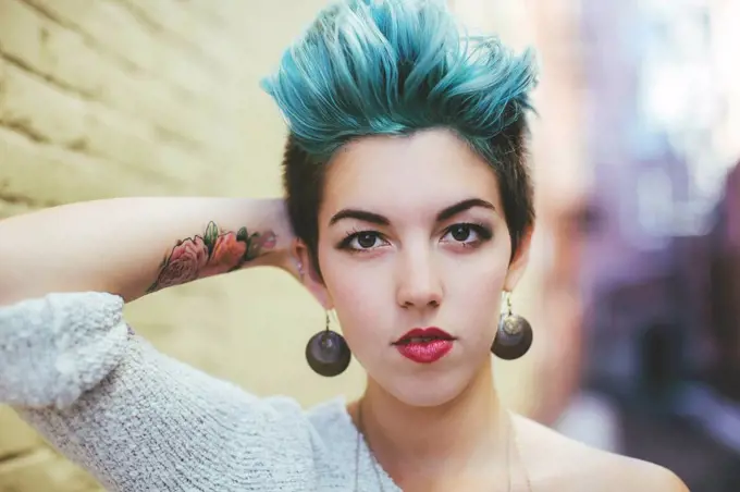 Stylish Caucasian woman with earrings and dyed hair