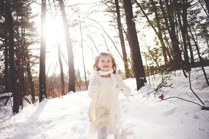 Caucasian girl running in snowy forest