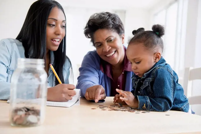 Black multi-generation family counting coins