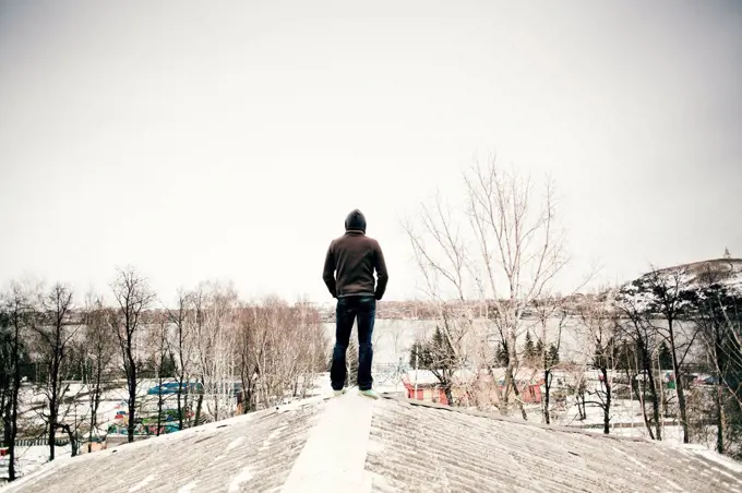 Caucasian man standing on snowy roof