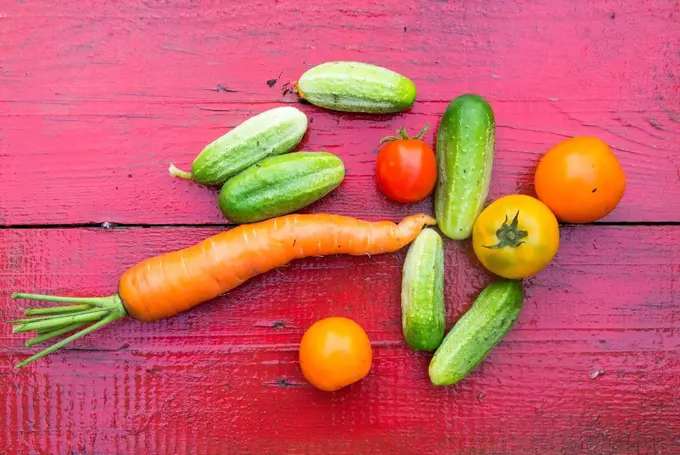 Close up of fresh vegetables on red wooden table