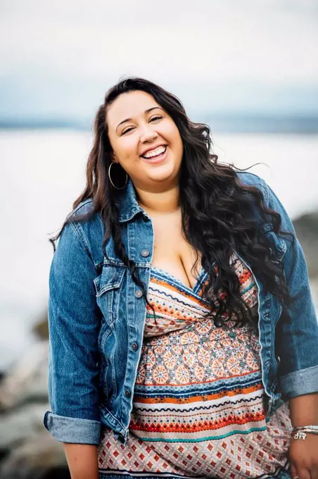 Smiling Mixed Race woman near ocean