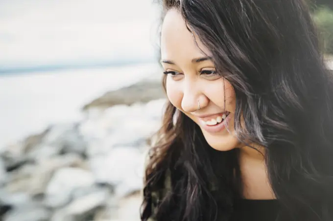 Smiling Mixed Race woman at ocean