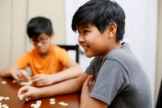 Native American boys playing spelling game at table