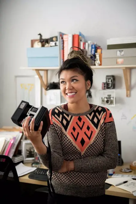 Mixed Race woman holding camera