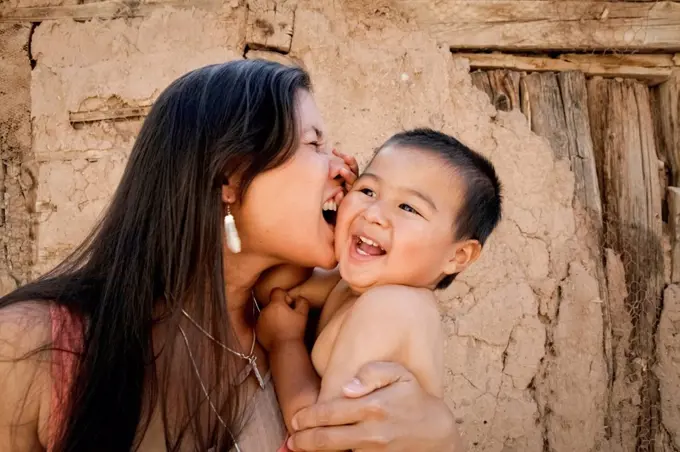 Playful mother holding son outdoors