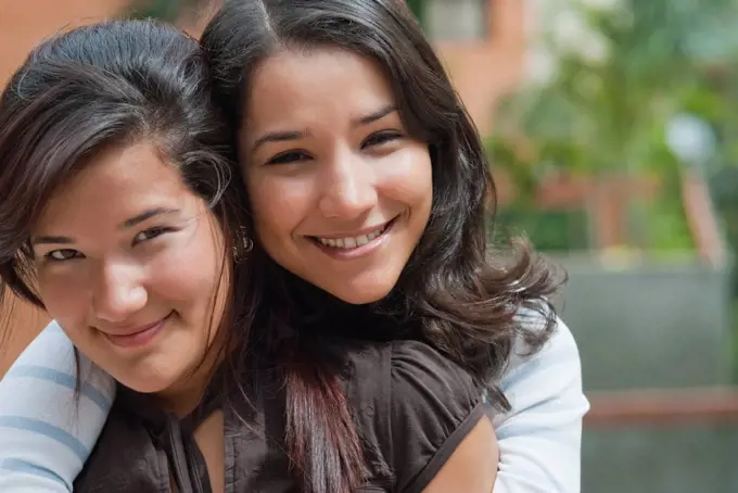 Hispanic sisters hugging