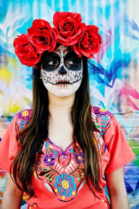 Hispanic woman wearing skull face paint