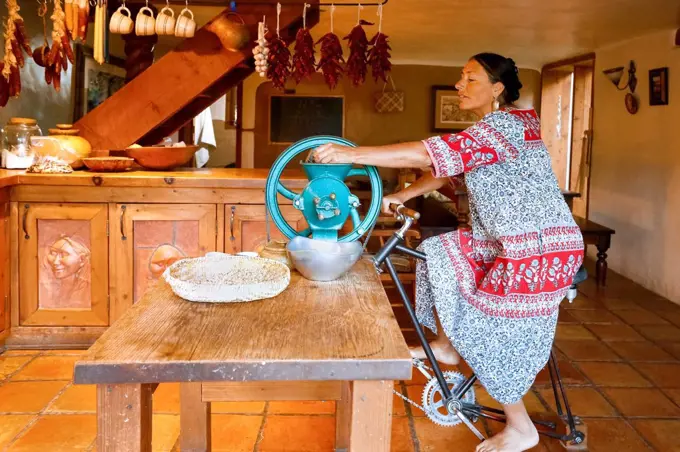 Woman pedaling to power grinder in kitchen