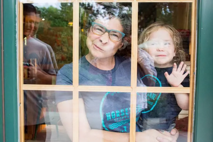 Caucasian mother and son making a face in door window