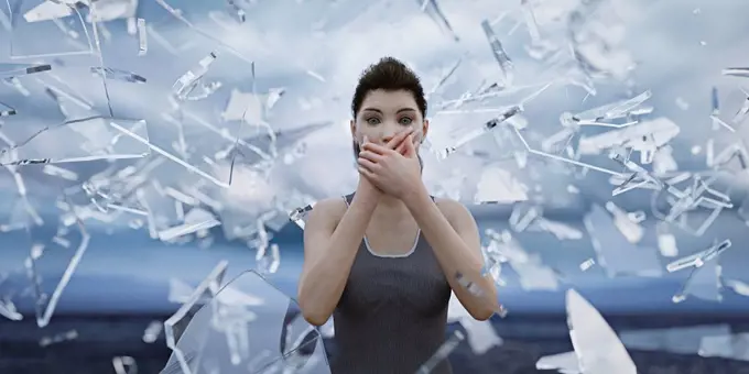 Shards of glass surrounding woman covering mouth with hands