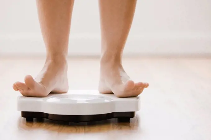 Caucasian woman´s feet standing on scale