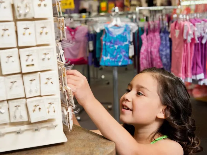 Mixed race girl looking at jewelry in store