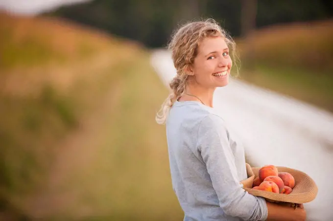 Caucasian woman picking fruit on rural road