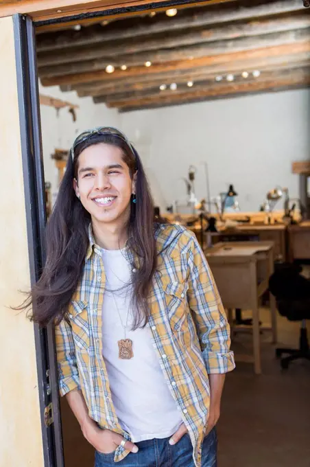 Mixed race man standing in doorway of art studio