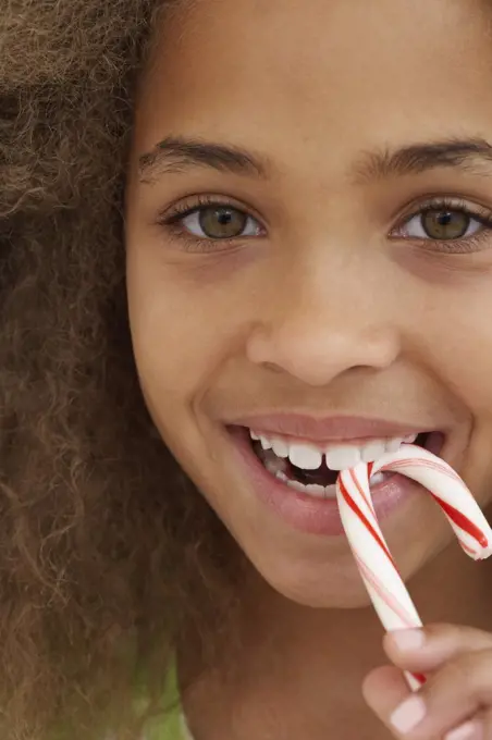 Close up of African American girl eating candy cane