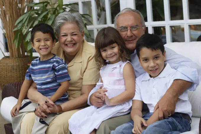 Hispanic grandparents hugging grandchildren