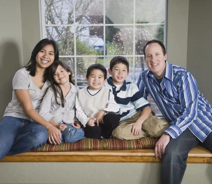 Mixed Race family in front of window