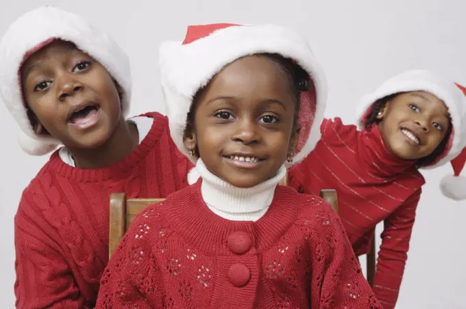 African siblings wearing Santa Claus hats