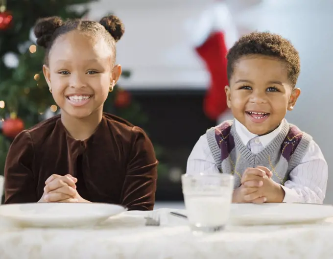 African American brother and sister sitting at table