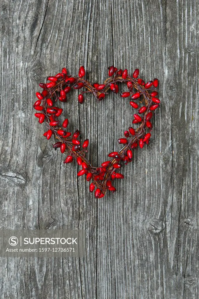 heart-shaped rose hips berry wreath in wooden door