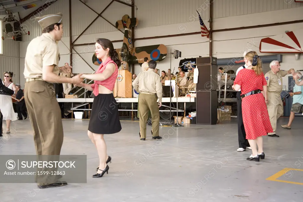 World War II actors dance in airport hanger at Mid-Atlantic Air Museum World War II Weekend and Reenactment in Reading, PA held June 18, 2009