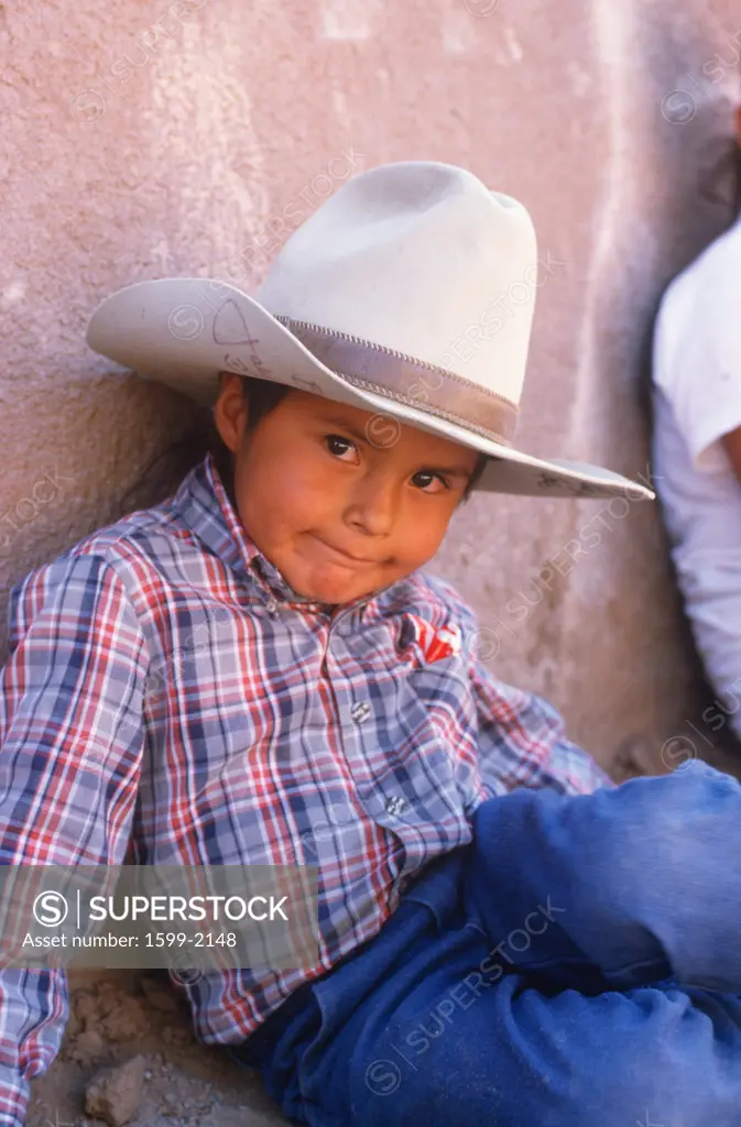 Young Native American cowboy lying on ground, Gallup, New Mexico