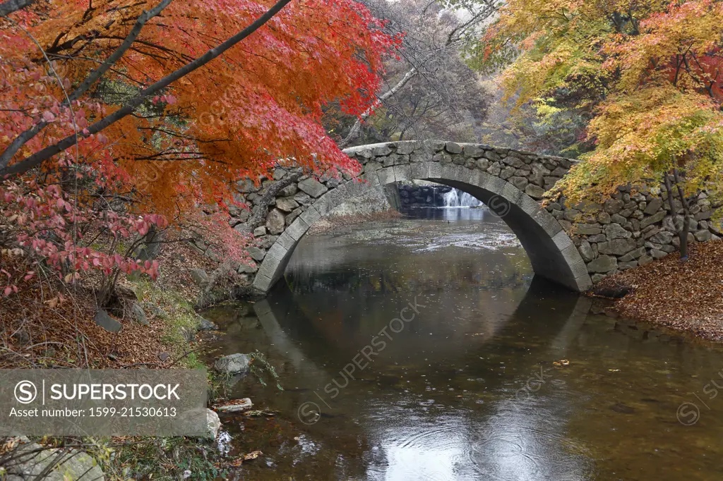 Autumn color and old stone arched bridge at Namsangol traditional folk village, Seoul, South Korea - NOVEMBER 2013