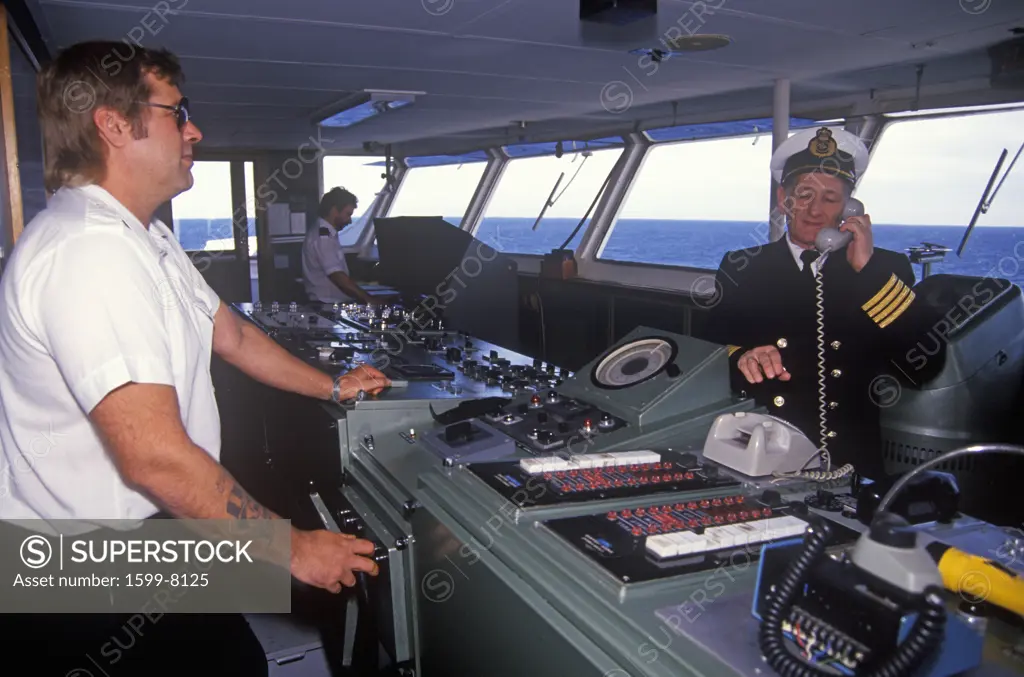 The captain of the ferry Bluenose speaking on the bridge phone while a crew member navigates the boat, Yarmouth, Nova Scotia