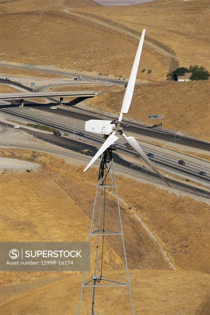 Wind turbine with freeway in background