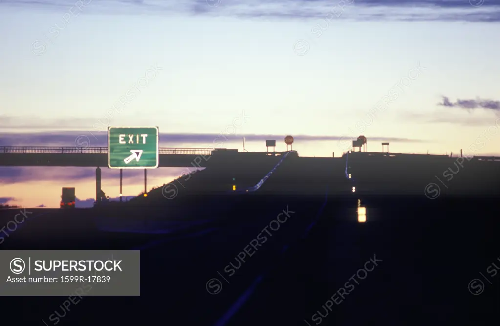 A freeway exit sign at dusk