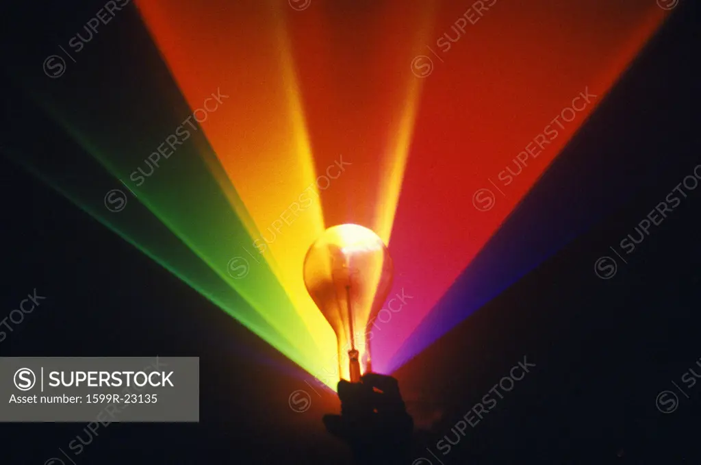 A lightbulb illuminated with an array of rainbow colors from a laser