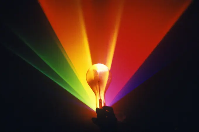 A lightbulb illuminated with an array of rainbow colors from a laser