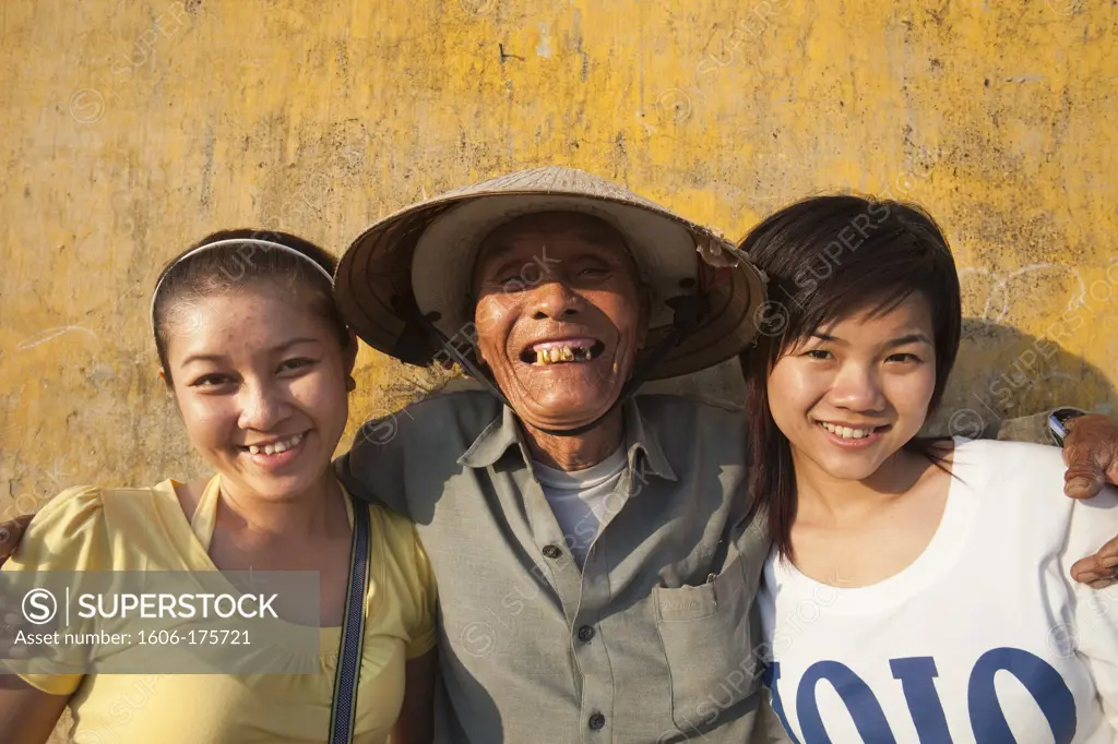 Vietnam,Hoi An,Elderly Fisherman Posing with Young Tourists