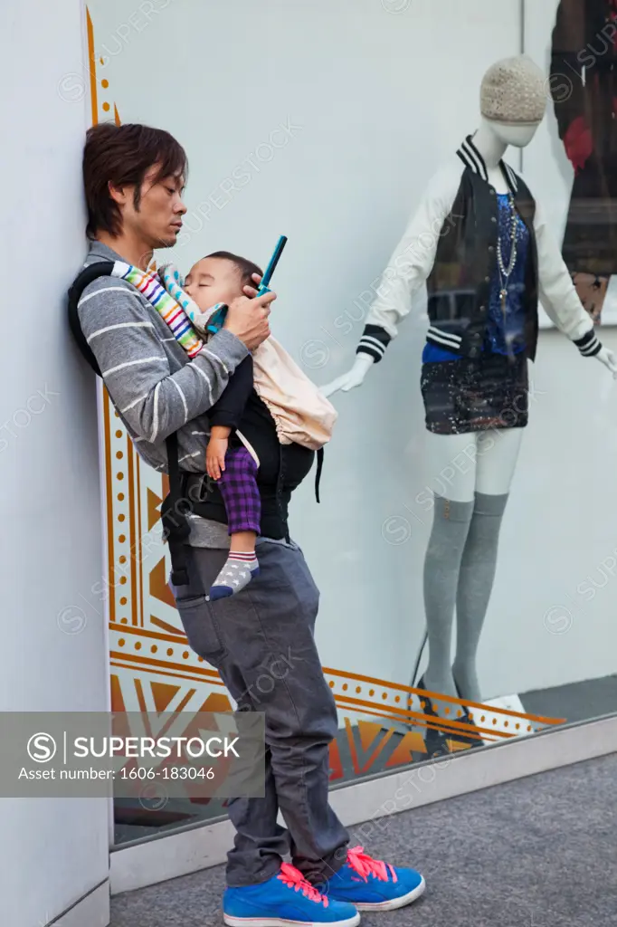 Japan,Tokyo,Harajuku,Takeshita Dori,Man Holding Baby and Mobile Phone