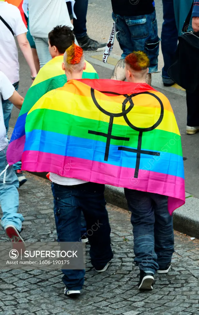 Two men with a pride flag draped around his shoulders in Paris Gay Pride Parade in France,Europe