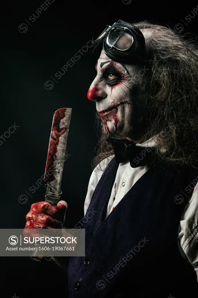 Portrait of a sadistic clown, a bloody knife in his hand