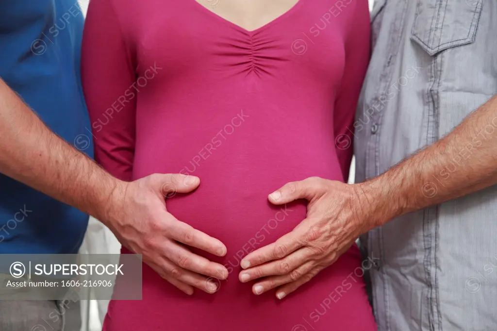 France, two men posing hand on a pregnant woman's belly.