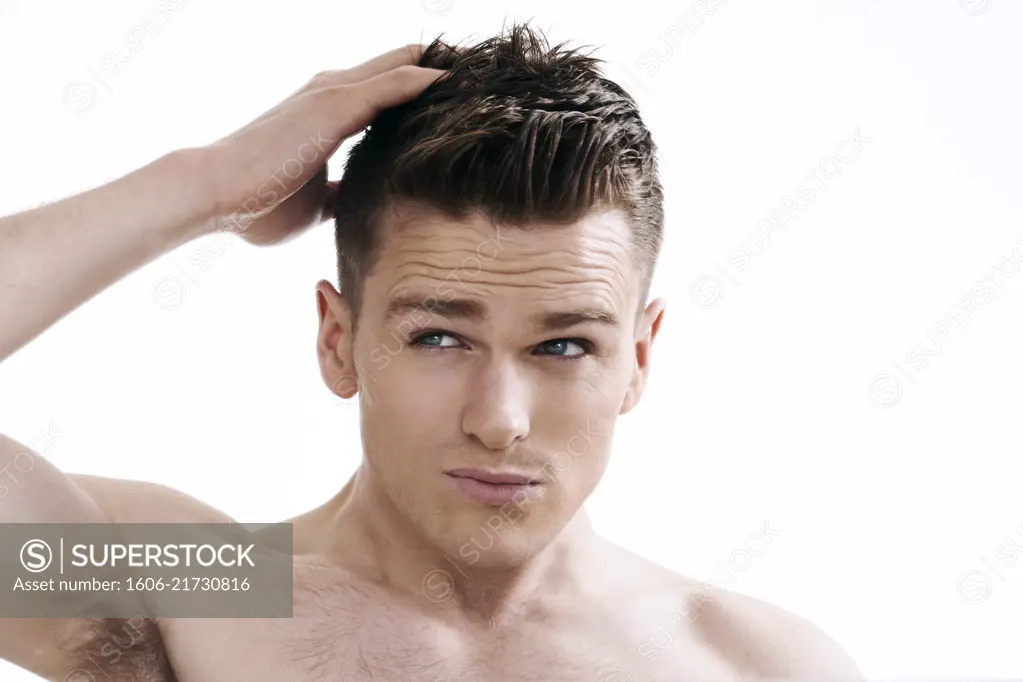 topless man, looking in the mirror, looking at his hair, hands in his hair, fixing his hair,