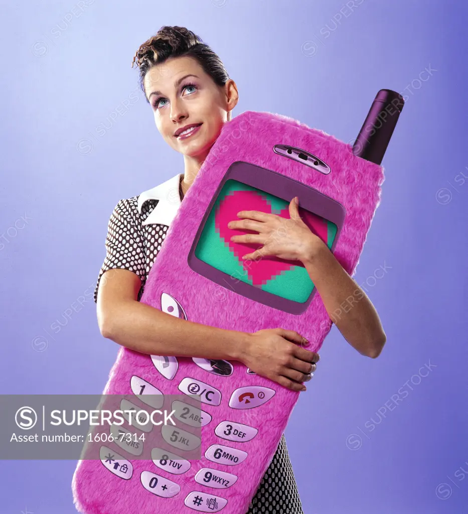 Smiling woman holding big cellphone in her arms