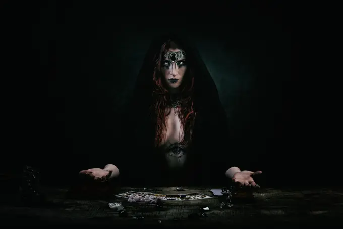 Portrait of a witch in front of her tarot game