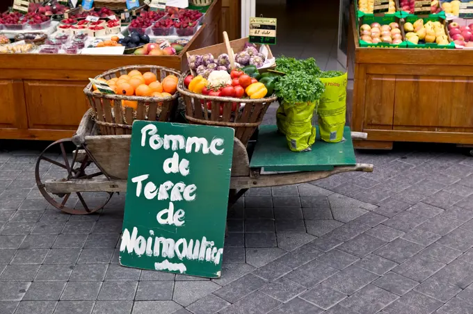 France, Vaucluse Department, Isle Sur La Sorgue, Vegetable Market Stall With A Billboard Firming Up The Origin Of The Potatoes, Vegetables In A Wheelbarrow