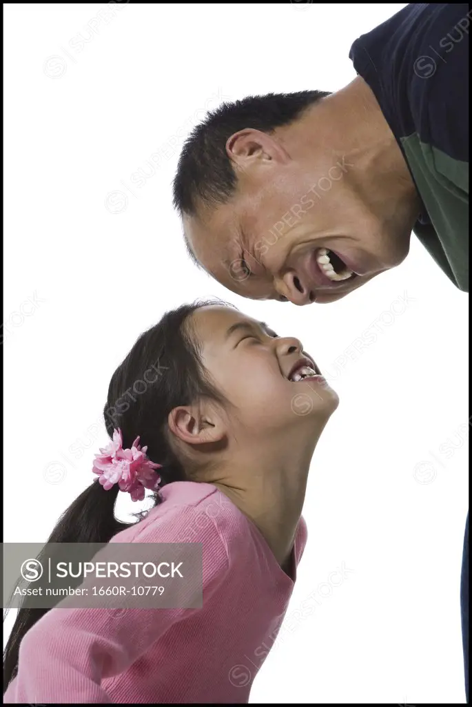 Profile of a girl and her father looking at each other, smiling