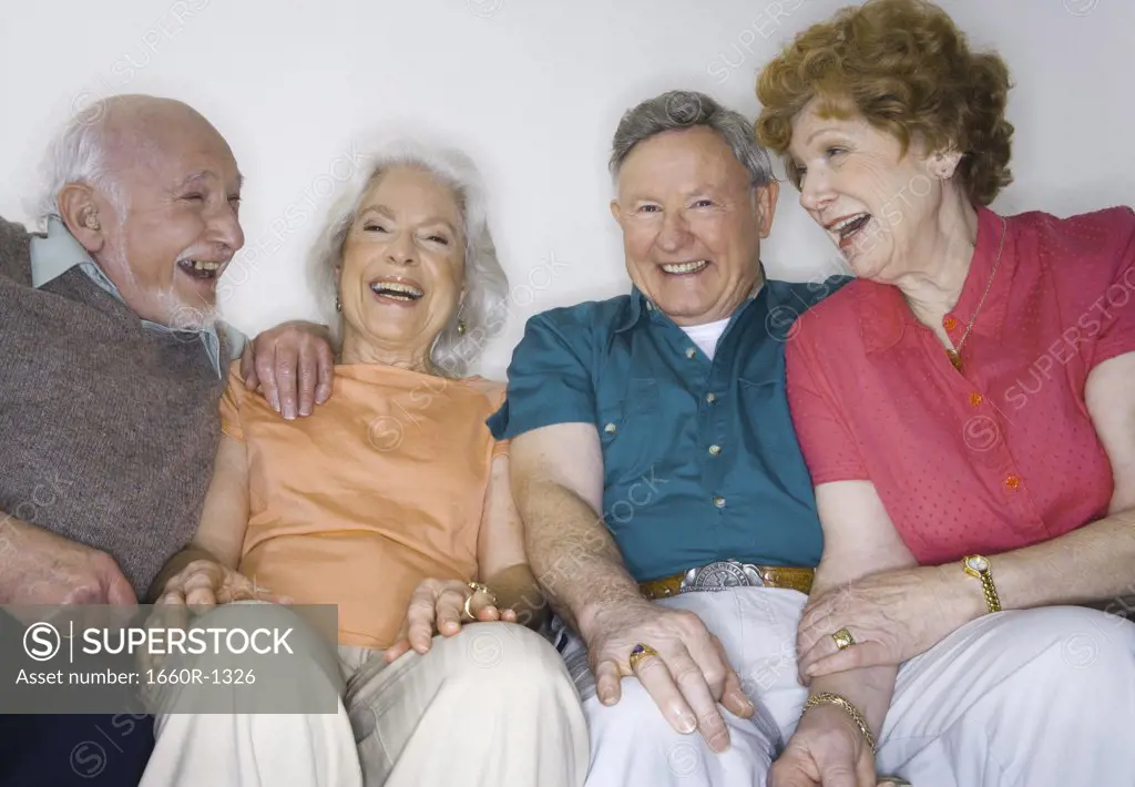 Portrait of two senior couples sitting together smiling