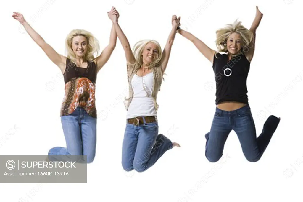 Portrait of three young women  holding hands and jumping