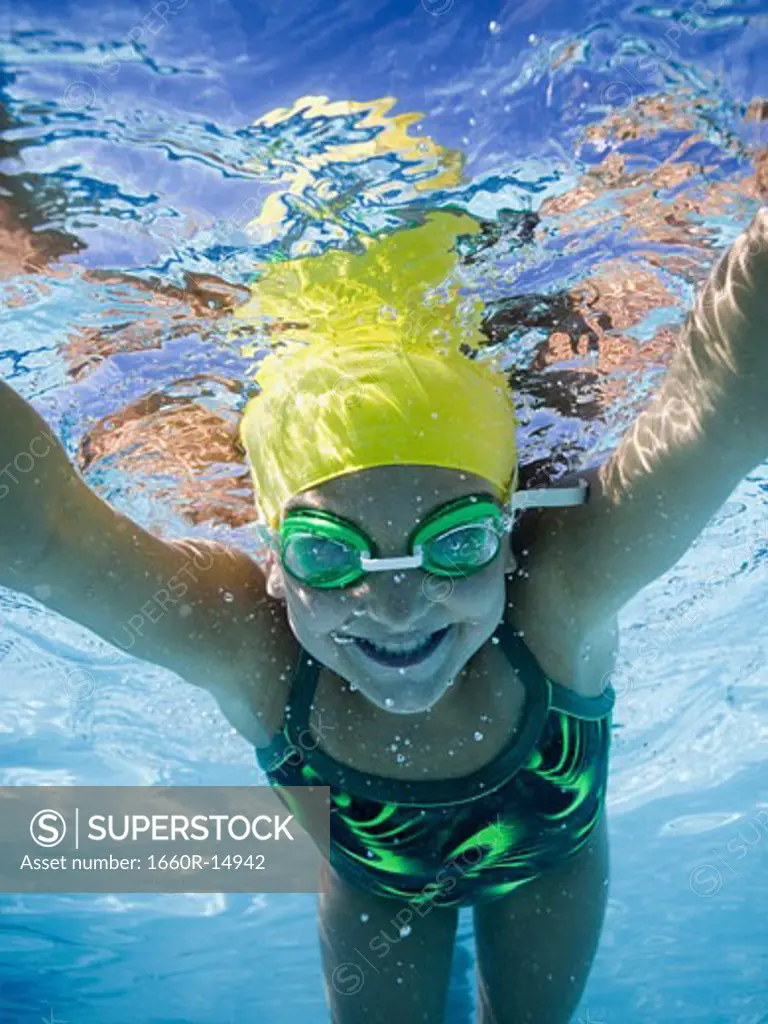 Girl swimming underwater in pool