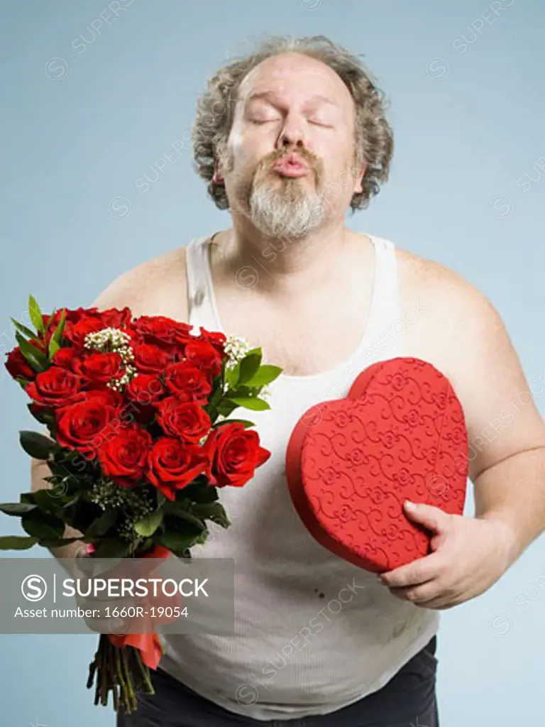 Disheveled man with red roses and heart box puckering